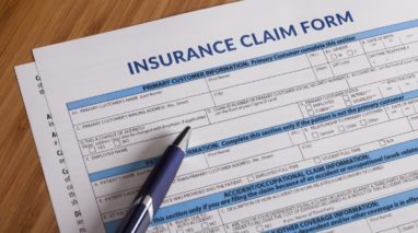 Paper insurance claim form with a pen