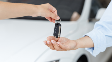 Young person handing over the keys to his car to his friend