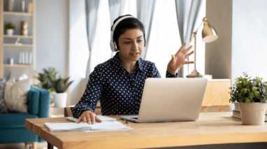 Woman having a video conference on her desktop computer in her home