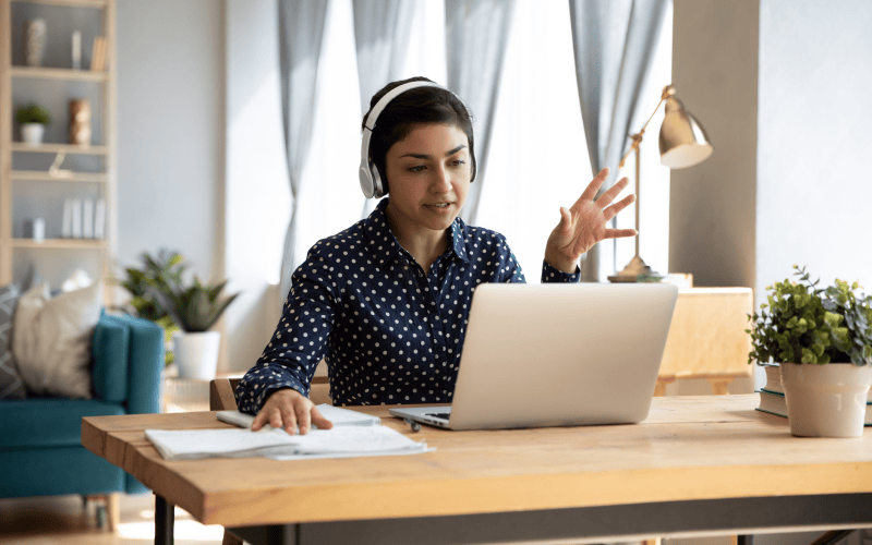 Woman having a video conference on her desktop computer in her home