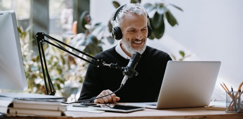 Cheerful senior man doing a podcast.