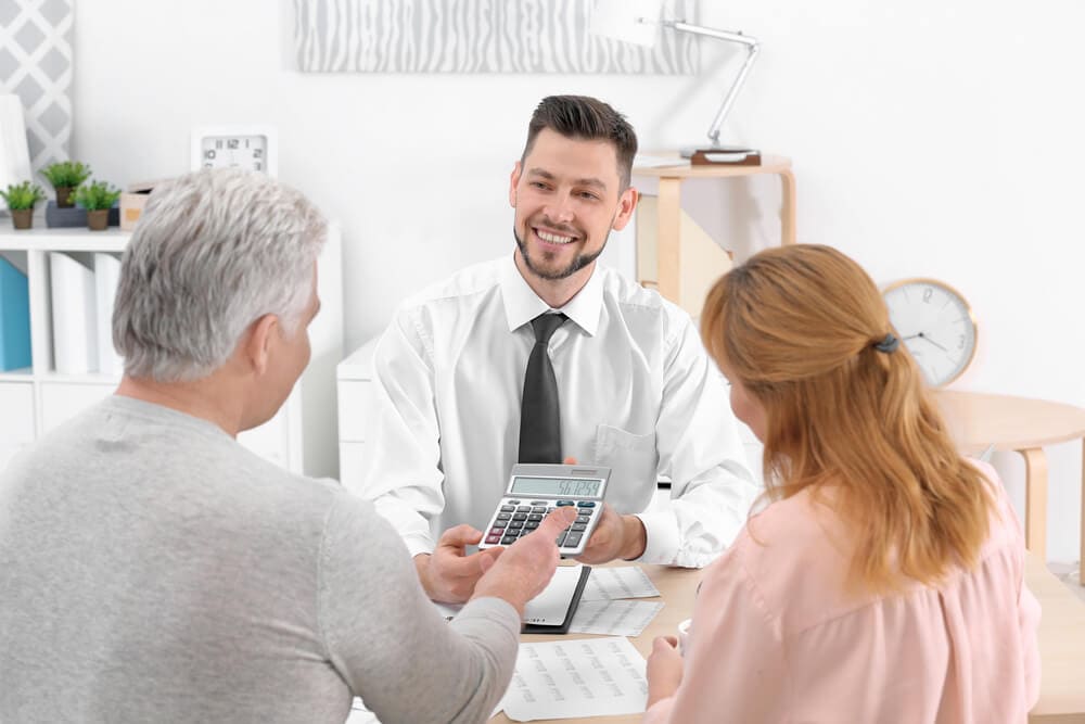 An insurance salesperson works with a senior couple on their insurance needs.