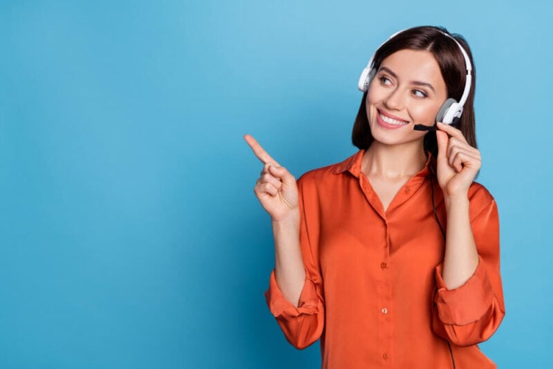 Smiling female agent pointing with finger