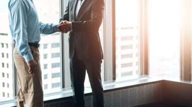 Mentor businessman shakes hand with young independent insurance protegee agent