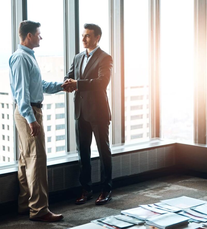 Mentor businessman shakes hand with young independent insurance protegee agent