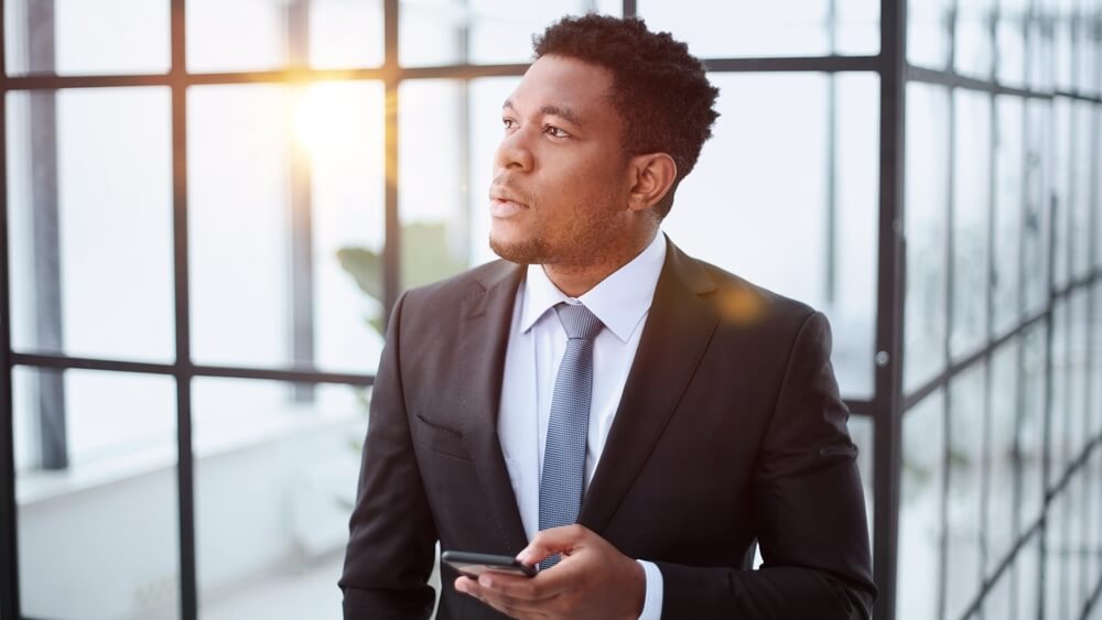 Pensive man in suit considers the steps it will take to become a successful independent insurance agent in Seattle.