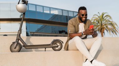 Businessman takes a break from his scooter in California to answer texts.