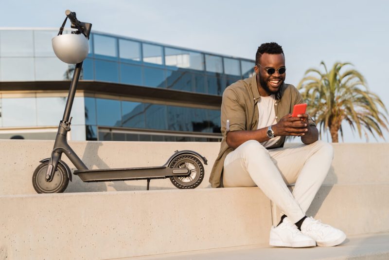 Businessman takes a break from his scooter in California to answer texts.