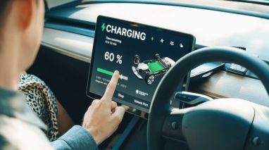 man looking at ev screen watching it charge