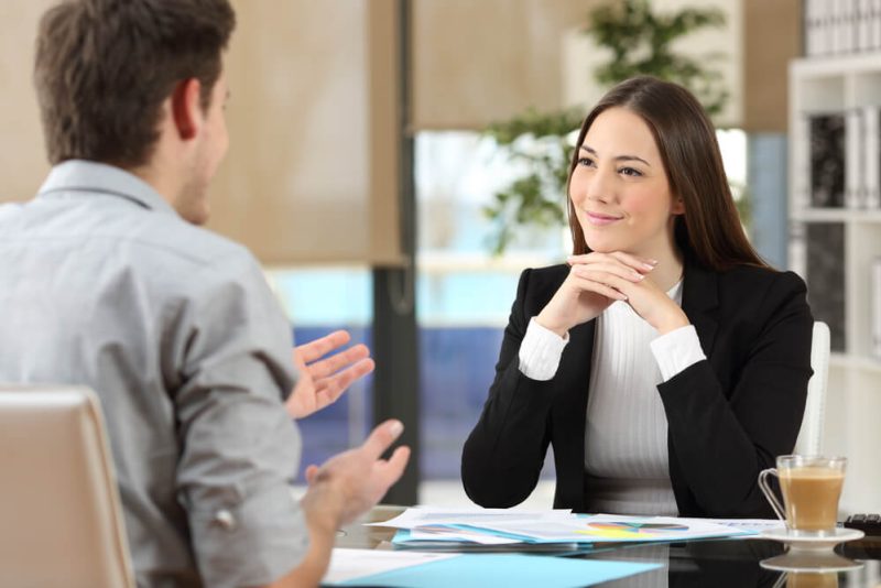 An independent insurance agent listens intently as her customer talks.