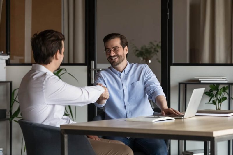 Two business partners shake hands - partner with Bluefire Insurance.